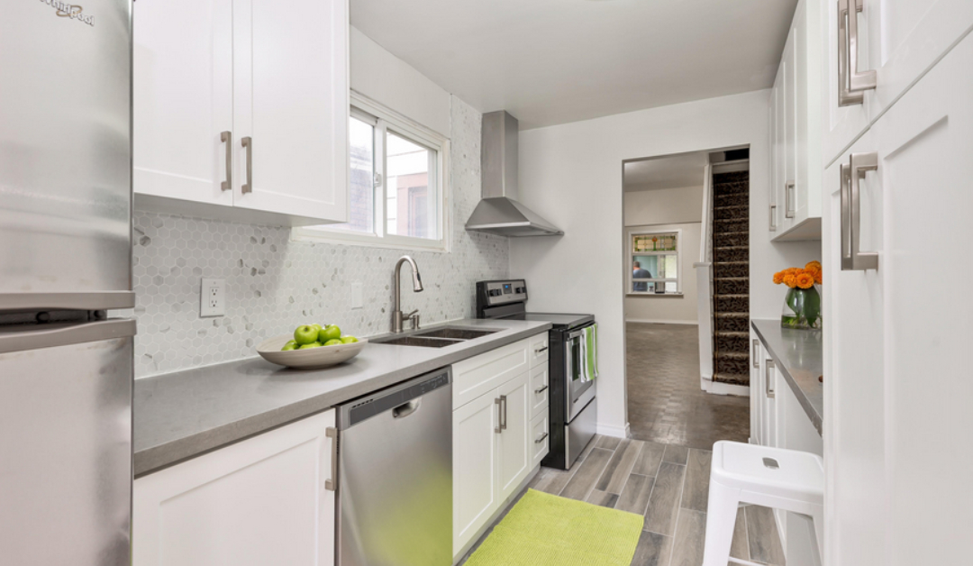 A clean, modern kitchen renovation with custom white cabinets and countertops installed in a GTA home by Envyland Kitchen Cabinet.