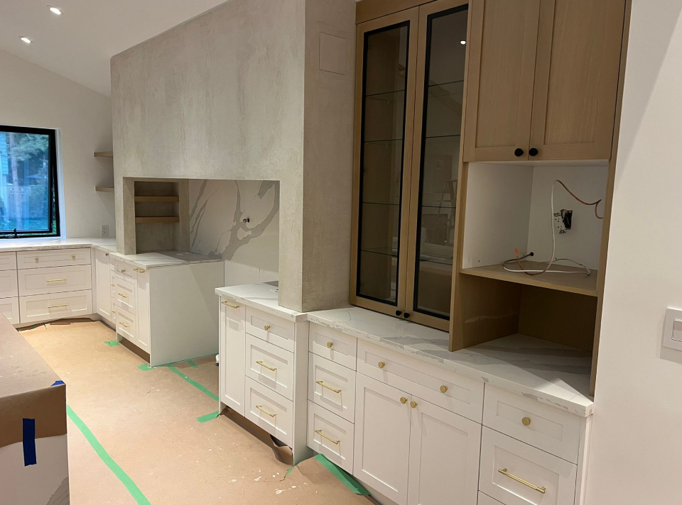 Custom white Shaker cabinets and light oak upper cabinetry with quartz countertops during an Oakville kitchen renovation by Envyland Kitchen Cabinet.