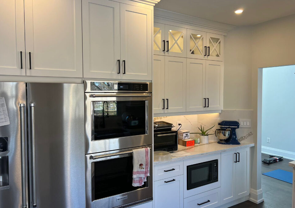 White custom Shaker kitchen cabinets with matte black hardware and built-in stainless steel appliances installed in an Oakville home by Envyland Kitchen Cabinet.