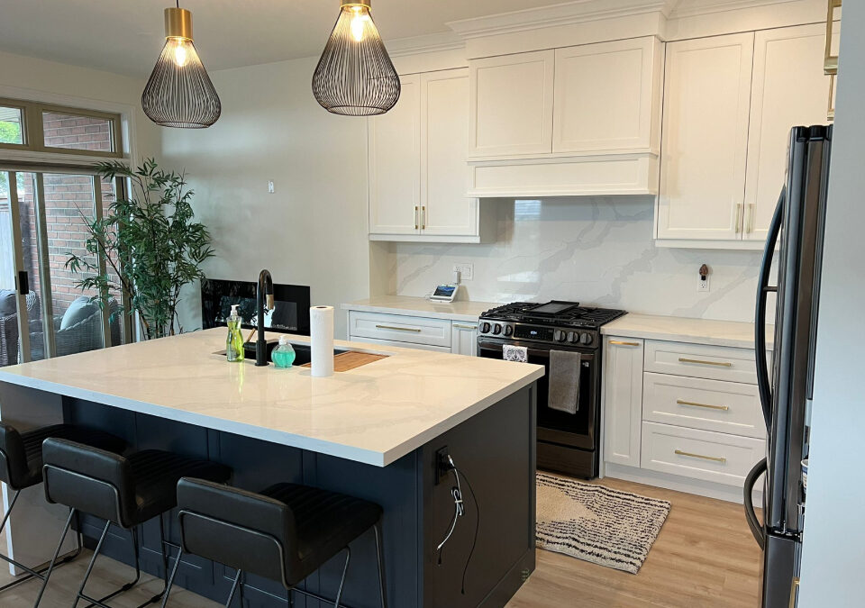 White marble-look quartz countertops and matching backsplash installed on a dark grey island and white cabinets in an Oakville kitchen renovation by Envyland Kitchen Cabinet.